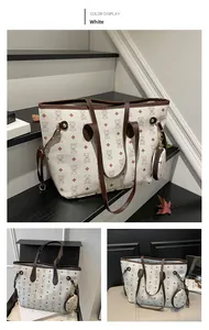 Detail view of large white tote bag with bear print, red diamond pattern and brown leather straps