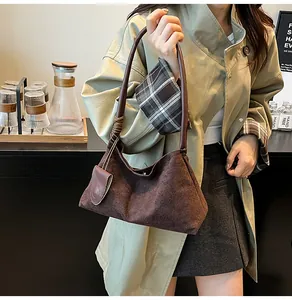 Détails du sac à bandoulière en daim marron foncé avec structure trapèze minimaliste