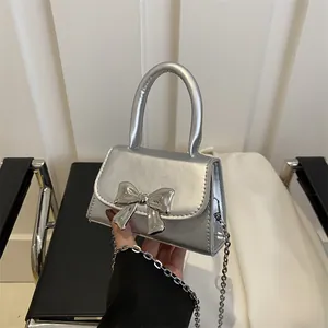 Silver mini crossbody bag with metallic bow detail and detachable chain strap