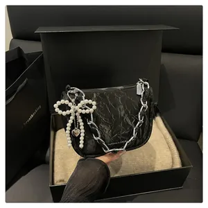 Chic black textured underarm bag with silver chain and pearl bow in a luxury gift box