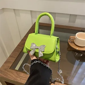 Neon green mini handbag with silver bow detail and chain strap for stylish women