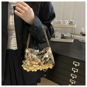 Detailansicht der goldenen Tasche mit großen Pailletten und Metallkette am Model