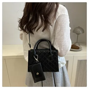 Détail d'un sac bandoulière matelassé noir avec mini pochette et bandoulière chaîne