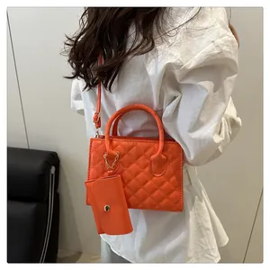 Détail du sac à main orange à motif losanges avec mini pochette assortie et bandoulière
