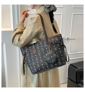 Detail of grey tote bag with bear pattern print, brown leather trim and mini purse