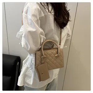 Détail d'un sac matelassé beige avec petit sac assorti et bandoulière réglable