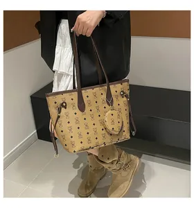 Detail of tan tote bag with bear print and matching round coin purse on a model