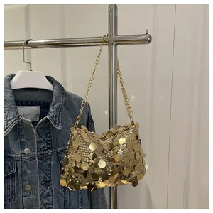 Detailansicht der goldfarbenen Paillettenstruktur und Metallkette einer schicken Tasche