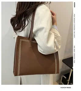 Bolso tote de cuero marrón con costuras blancas en contraste y correas largas al hombro