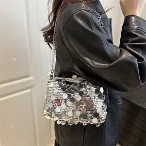 Silberne Pailletten Umhängetasche mit Metallkette, getragen von Model in Lederjacke