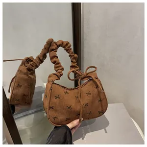 Detail of brown corduroy bag with black bow prints and ruffled scrunchie style handle