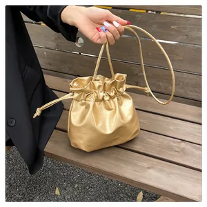 Detailed macro view of golden drawstring bucket bag with premium metallic leather texture