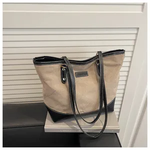 Retro khaki canvas tote bag with black leather straps and diamond quilting pattern