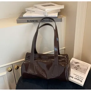 Elegante bolso de hombro baguette marrón oscuro en cuero brillante con efecto arrugado