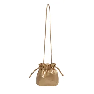 Chic gold drawstring bucket cosmetic bag in soft metallic leather with top handle