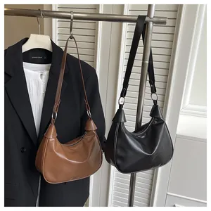 Vue détaillée des sacs croissant marron et noir avec anneaux métalliques argentés