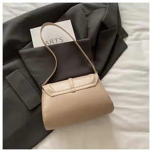 Detail view of a beige minimalist crossbody bag featuring a sleek magnetic flap closure