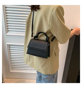 Borsa a tracolla nera minimalista con un dettaglio unico del manico intrecciato a nodo