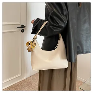 Detail of off-white lychee grain tote bag with decorative silk scarf on shoulder