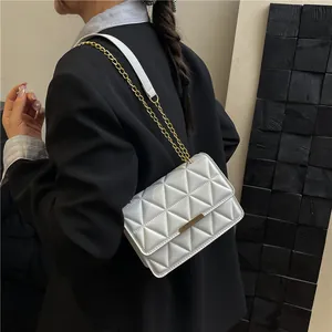 White quilted shoulder bag with gold chain strap and metallic bar for elegant women's style