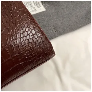 Détail macro du cuir marron gaufré crocodile avec surpiqûres et finitions des bords