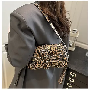 Detail of leopard print handbag with silver rivets and buckled wide strap on shoulder