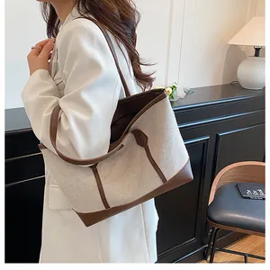 Detail of minimalist contrast tote bag showing canvas texture and brown leather straps