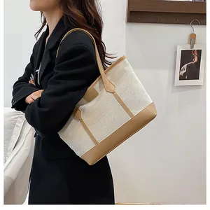 Detail of canvas tote bag with brown leather trim and triangle reinforcement stitching