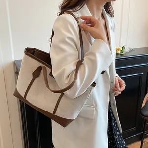 Contrast color canvas tote bag with brown leather trim shown on model for daily commuting