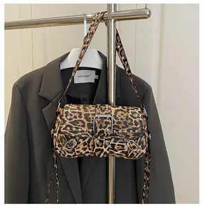 Dettaglio della borsa baguette leopardata con borchie argentate e fibbia in metallo