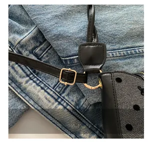 Detail showing adjustable black leather strap with gold buckle on herringbone fabric bag