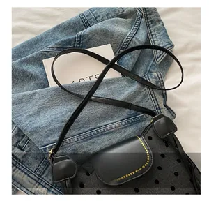 Detail of black polka dot mesh crossbody bag with leather flap and slim shoulder strap