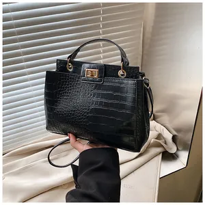 Gros plan sur la texture cuir crocodile noir et le fermoir tournant en métal doré
