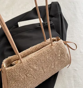 Detail view of plush fleece mini phone bag with golden zipper and leather strap
