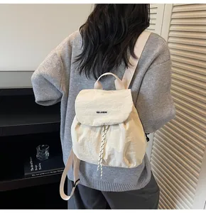Close-up of cream canvas backpack featuring YOU JI BEAR logo and drawstring closure