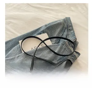 Detail of minimalist black matte leather crossbody bag with comfortable shoulder strap