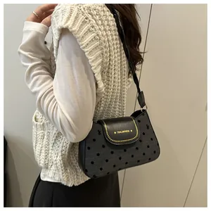 Detail of vintage polka dot underarm bag with gold rivets and Tidal Dryness logo