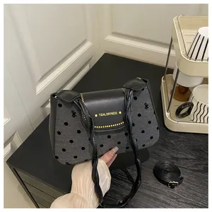 Detail of TIDAL DRYNESS black crossbody bag with polka dot texture and bow patterns