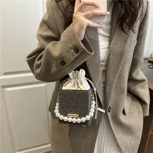 Suede drawstring bucket bag with leopard print, faux pearls and gold chain strap