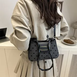 Minimalist polka dot canvas shoulder bag with black leather trim and knot handle