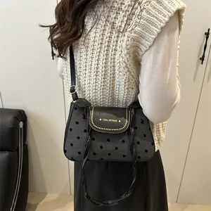 Retro grey polka dot shoulder bag with black leather flap and braided handle on model
