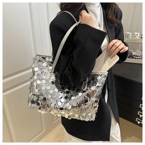 Detail shot of a silver sequin tote bag showing the spacious interior with a tablet