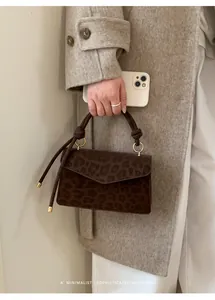 Detailed view of the leopard print square handbag with knotted handle and gold hardware