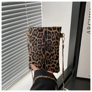 Close-up of leopard print crossbody bag with gold chain strap and textured finish