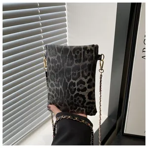 Close-up of leopard print mini bag featuring a gold metal chain strap and PU texture