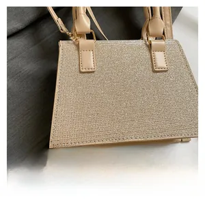 Close-up of champagne gold glitter fabric and khaki leather handle on a chic bag