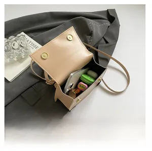 Beige faux leather crossbody bag interior showing storage space for phone and earphones