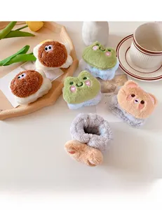 Detailed view of soft plush wristbands with cartoon frog and bear designs on a tray