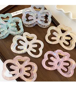 Detailed view of six iridescent acrylic hollow bow hair claws in various pastel colors