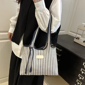 Chic blue and white striped canvas tote bag with leather patch and blue drawstring detail